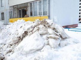 Street photo. Big snowdrifts in the city. The path after the passage of the snowplow. photo