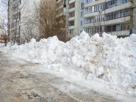 Street photo. Big snowdrifts in the city. The path after the passage of the snowplow. photo