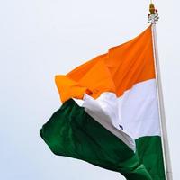 India flag flying high at Connaught Place with pride in blue sky, India flag fluttering, Indian Flag on Independence Day and Republic Day of India, tilt up shot, Waving Indian flag, Har Ghar Tiranga photo