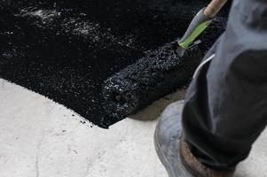 Waterproofing the floor in a private house, applying liquid resin to the floor, concrete screed and waterproofing. photo