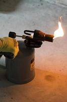 soplete de gasolina con fuego ardiente, el uso de un soplete en la construcción. foto