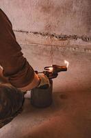 Gasoline blowtorch with a burning fire, the use of a blowtorch in construction. photo