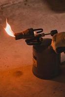 Gasoline blowtorch with a burning fire, the use of a blowtorch in construction. photo