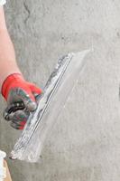 Wide spatula for leveling the surface of walls and ceilings. photo