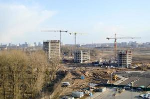 vista superior de un gran sitio de construcción con grúas y edificios que albergan rascacielos monolíticos de hormigón de varios pisos de la gran ciudad de la metrópolis foto