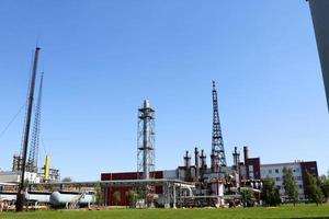 A large concrete technological industrial installation at a chemical petrochemical refinery with capacitive pipes by pumps compressors heat exchangers by pipelines and buildings photo