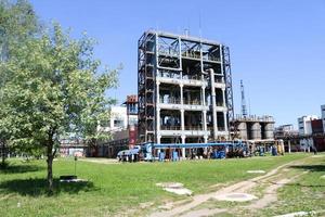 A large concrete technological industrial installation at a chemical petrochemical refinery with capacitive pipes by pumps compressors heat exchangers by pipelines and buildings photo