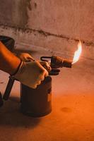 Gasoline blowtorch with a burning fire, the use of a blowtorch in construction. photo
