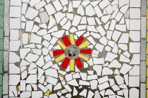 Texture of a ceramic mosaic of glass fragments of various colors with a flower pattern. The background photo