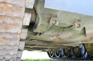 Rusty iron dirty metal heavy track caterpillar of a large green military off-road armored deadly dangerous Russian Syrian battle tank and bottom photo