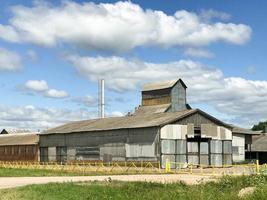 gran edificio agrícola agrícola con equipos, casas, graneros, granero foto