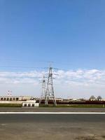 planta de energía con torres y cables de alto voltaje de metal alto, pilares contra el fondo de edificios industriales foto