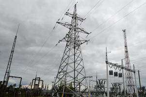 línea de transmisión metálica con los componentes de la red eléctrica, el sistema de equipos de potencia para la transmisión de electricidad, corriente eléctrica con el transformador en la central eléctrica foto