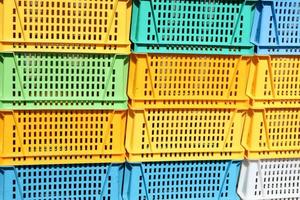 Texture from colored plastic colored yellow blue green rectangular boxes with holes for goods, bottles photo