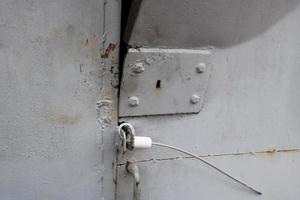 la textura de la puerta de metal de hierro doblada y rota azul con una cerradura de un cable de metal astuto hecho en casa. el fondo foto