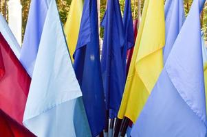 Texture of multi-colored festive red, blue, yellow flags made of fabric. The background photo