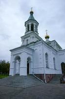 una gran iglesia de piedra blanca con una cúpula dorada y una campana en europa oriental es un cristiano ortodoxo para las oraciones de dios foto