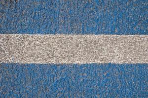 Asphalt is painted blue with a white stripe in the center. Road marking. Textured background. copy space. Top view. photo