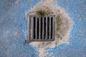 Metal grating for storm sewers to drain water from the road. Top view. photo