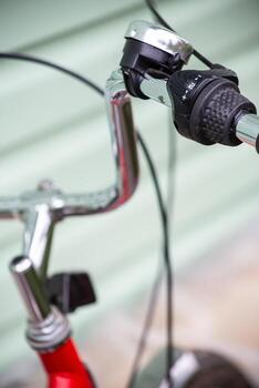 Handlebars of a bicycle with a signal and a speed switch attached to it. Close-up. photo