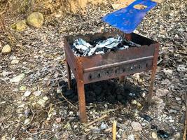 barbacoa para cocinar carne al fuego, barbacoa y recreación al aire libre vieja, oxidada, hierro, metal foto