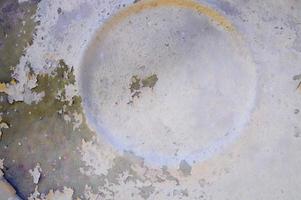 The texture of a voluminous metal wall with a circular pattern with a shabby old paint painted peeling and drawn circle. The background photo