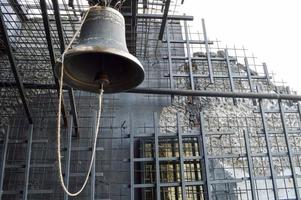 A large iron metal bell on a church church is an old ancient religious Christian