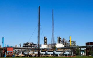 A large concrete technological industrial installation at a chemical petrochemical refinery with capacitive pipes by pumps compressors heat exchangers by pipelines and buildings photo