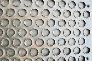 textura de una fuerte superficie de hierro industrial con un patrón industrial de círculos. el fondo foto
