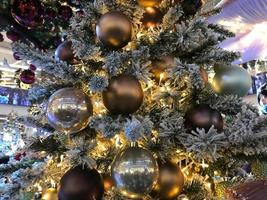Fir tree decorated with christmas balls. Close-up view of beautiful christmas tree with colorful baubles and illuminated garland. Sparkling and fairy background. New year holiday photo