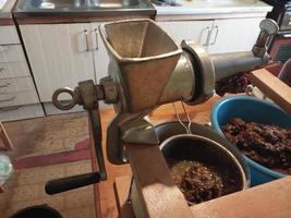 exprimir jugo de uva con una picadora de carne manual de tornillo foto