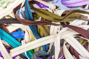 Close-up view of many colorful zippers. Multicolored zippers background photo