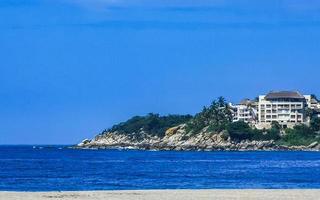 Beach sand blue water huge surfer waves Puerto Escondido Mexico. photo