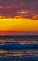 colorido atardecer dorado gran ola y playa puerto escondido mexico. foto