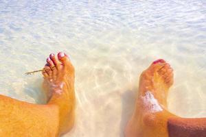 Feet in clear turquoise water on Holbox island Mexico. photo