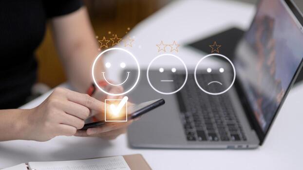 Customer service evaluation concept. using a smartphone is pressing face emoticon smiling in satisfaction on virtual touch screen. photo