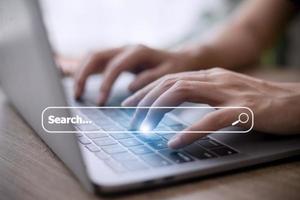 People hand using laptop or computor searching for information in internet online society web with search box icon and copyspace. photo