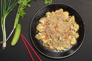 Fried rice with vegetable and egg in plate on black background. photo