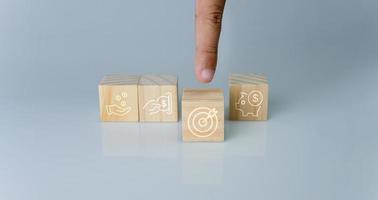 Hand pointing at one wood cube block with target icon . Concept of business strategy and goal action plan. photo