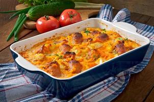 Casserole with sausage, bacon and apples in a pumpkin-cheese sauce photo