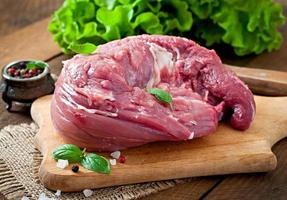 Piece of raw pork tenderloin on a wooden background photo