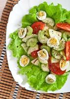 Salad of tomatoes, cucumbers and quail eggs photo