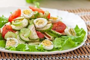 Salad of tomatoes, cucumbers and quail eggs photo