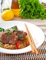 Pork medallions in oyster sauce with noodles photo