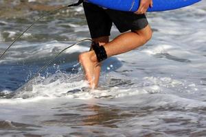 A man walks barefoot on the sand by the sea photo