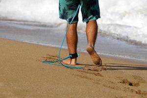 A man walks barefoot on the sand by the sea photo