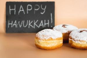 Happy Hanukkah. Traditional Jewish dessert Sufganiyot. Celebrating Judaism holiday. Donuts with jam and sugar powder. photo
