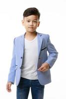 Half-body portrait of a young Asian boy in a casual jacket posing confidently looking at the camera on a white background. photo