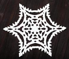 paper snowflake on dark brown wood table photo