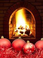 red Christmas balls and tinsel with fireplace photo